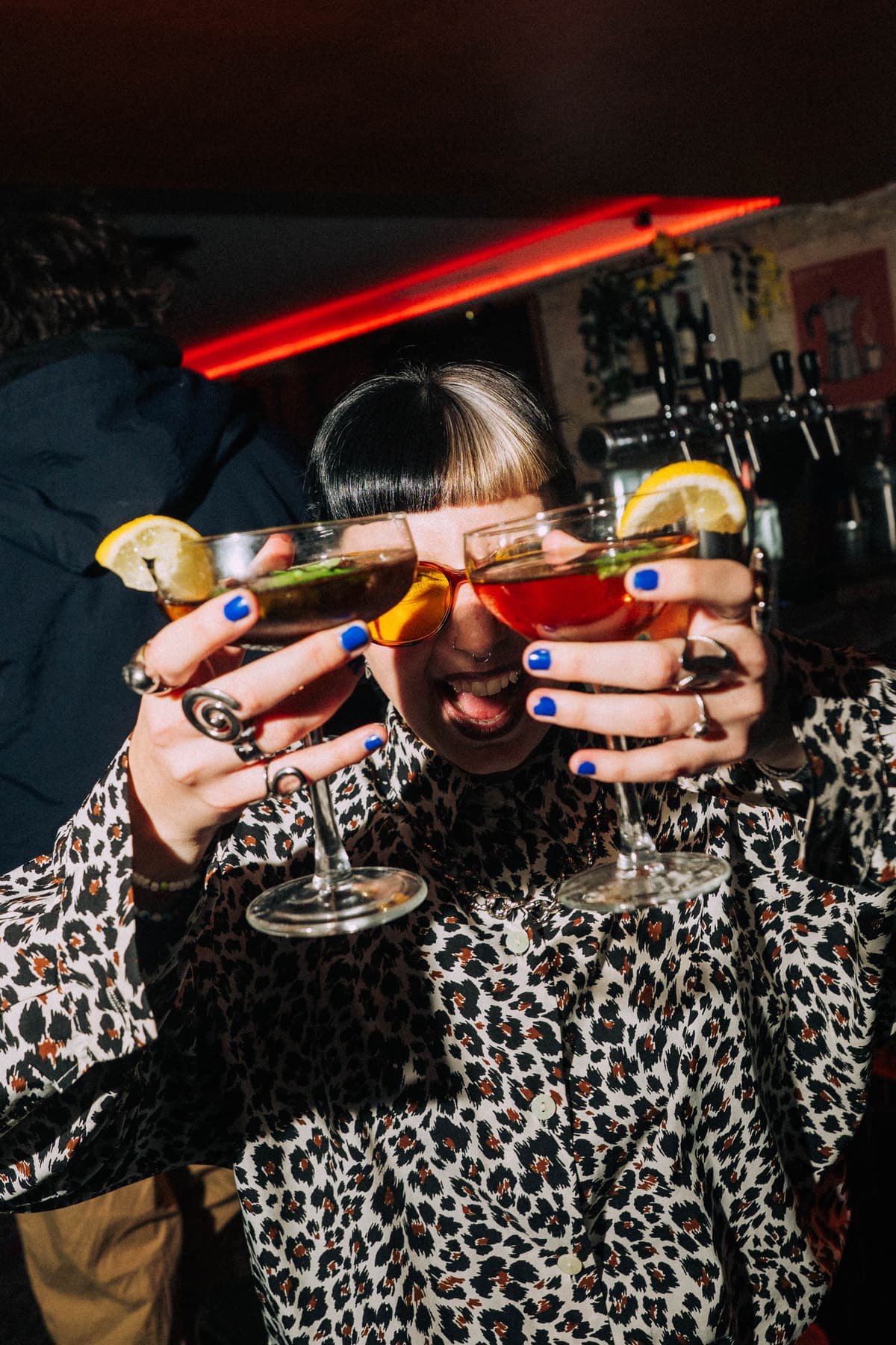 Invitée présente deux cocktails devant le bar