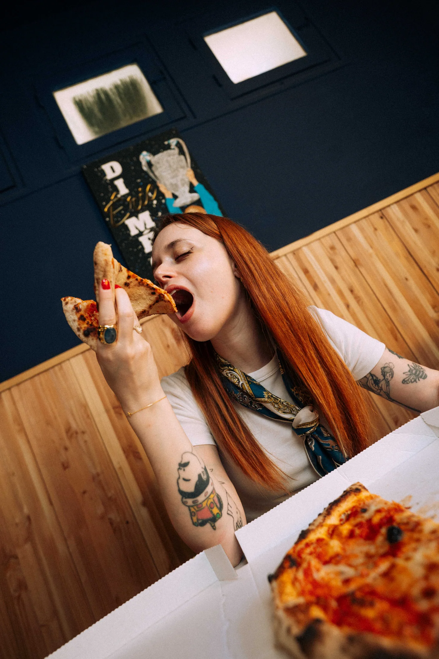 Modèle dégustant une part de pizza Casa Di Meco